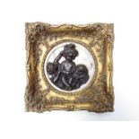 A bronze and marble high relief plaque depicting children in ornate gilt frame.