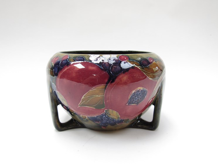 A William Moorcroft Pomegranate design bowl on Art Nouveau triform supports,