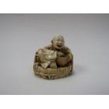 A 19th Century ivory netsuke of a man with rice basket, intricate foliate surround,