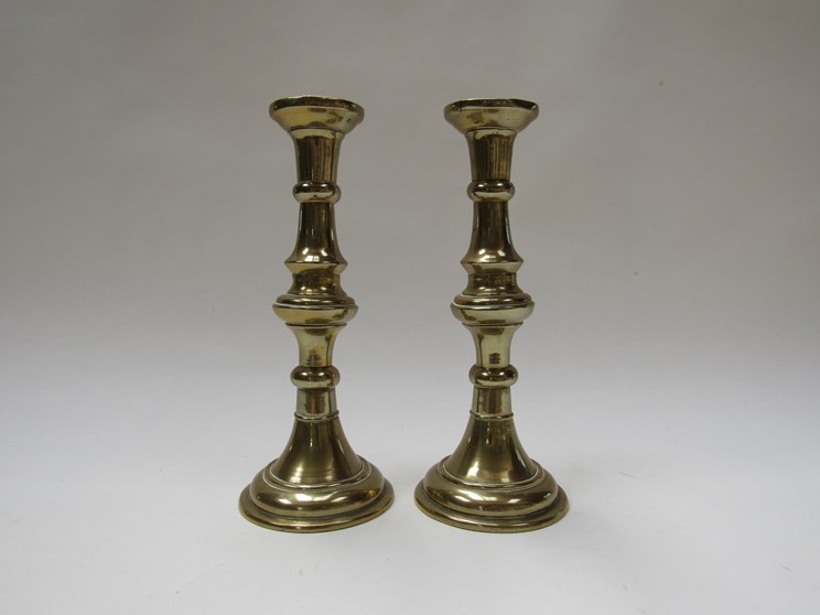 A pair of 19th Century brass candlesticks, 25.