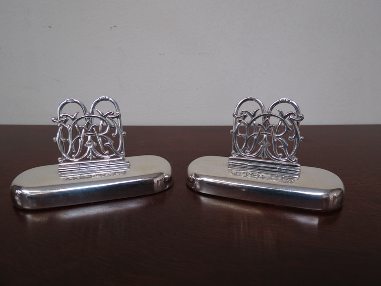 Two Sampson Mordan & Co silver name place holders with monogram clasp, weighted bases,