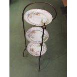 An Edwardian brass three tier cake stand with ceramic plates