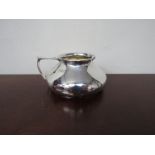 A silver cream jug of squat form, London, gilded interior, dented,