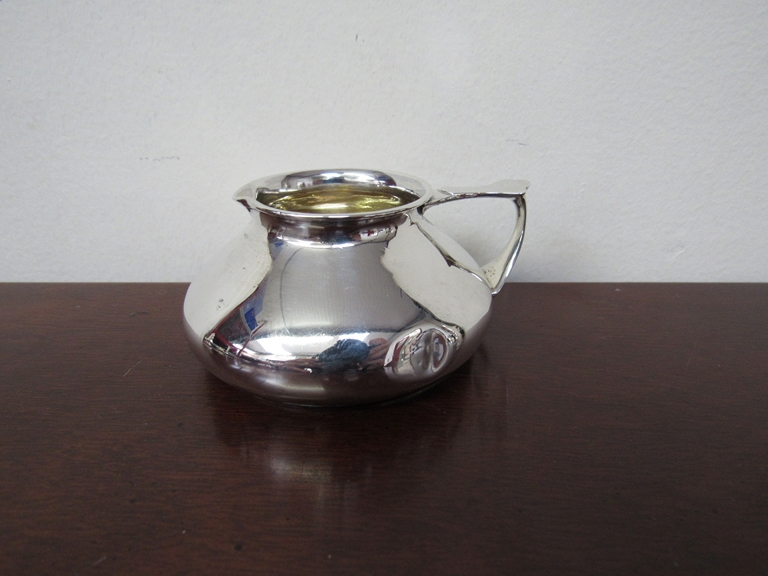 A silver cream jug of squat form, London, gilded interior, dented, - Image 2 of 3