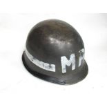 A mid 20th Century US Army helmet with Military Police (MP) lettering,