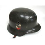 A Third Reich era German M1935 helmet with twin decals, rolled rim and riveted air vents,