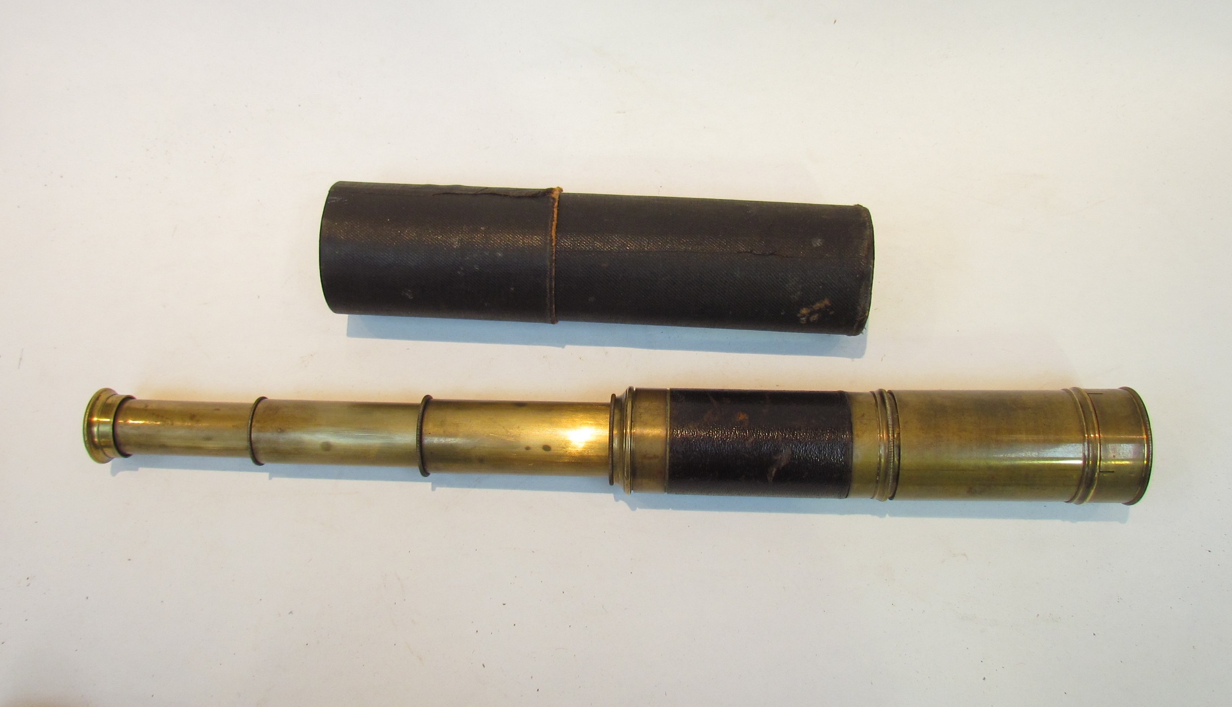 A 19th Century brass three draw telescope with leather binding and original card tube