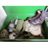 A metal trunk of military clothing including boots,