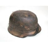 A copy of a German M40 helmet with distressed tan paintwork and mesh covering