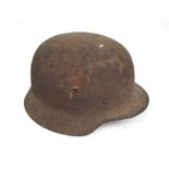 A WWII German helmet with shrapnel hole to the back,