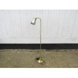 A brassed metal standard lamp with adjustable single spot