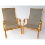 A pair of Danish design formed laminated bentwood lounge chairs with cream canvas weave seats