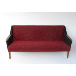 A 1940's Danish three seater sofa with teak armrests and original black and red upholstery.