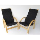 A pair of Danish design formed laminated bentwood lounge chairs with black canvas weave seats,
