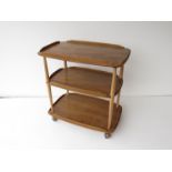 A light wood Ercol three tier trolley on castors