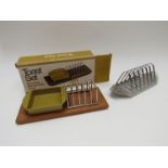 A Danish teak toast set in original box together with a Robert Welch Old Hall stainless steel toast