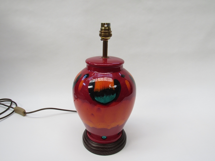 A Poole volcano glaze lamp base on wooden plinth,