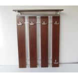 A wood and metal wall hanging coat rack.