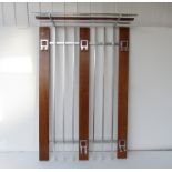 A wood and metal wall hanging coat rack.