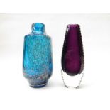 A blue glass vase by Schott Zwiesel and another purple glass vase with ribbed edges.