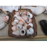 A basket of various bisque and china dolls heads