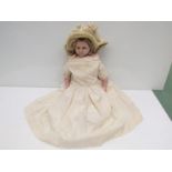 A 19th Century wax doll, cloth body in silk dress and bonnet,