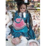 A bisque head, composition body girl doll in green silk dress with bonnet, 75cms,