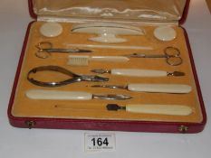 A cased bone handled manicure set