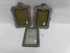 A pair of silver photo frames and one other