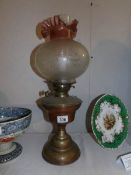 A brass oil lamp with etched shade