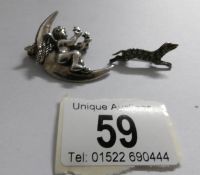 A silver cherub on moon brooch and a silver dog brooch