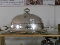 A large silver plated food dome on stand