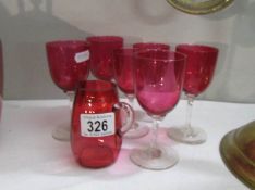 A cranberry glass jug and 3 cranberry glass goblets