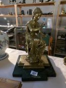 A polished bronze figure of a lady with a butterfly,