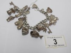 A silver charm bracelet with approximately 14 silver charms