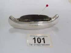 A silver pin cushion in the shape of a canoe with Birmingham hall mark