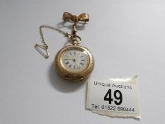 An early 19th century 14ct gold ladies fob watch in chased gold with enamel face and surmounted by