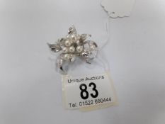 A silver brooch set cultured pearls fashioned as a spray of flowers with 9 pearls