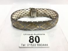 A fine mesh link bracelet inlaid with gold and silver,