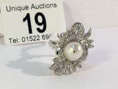 A high carat white gold floral diamond ring with central pearl,