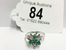 A diamond and emerald ring in 14ct gold fashioned as a flower head,