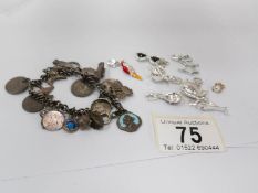 An early 20th century charm bracelet together with later loose charms including some silver