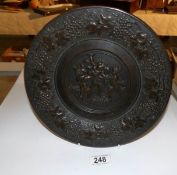 A bronzed metal plate with embossed cherubs