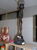 A tall art deco style spelter figurine lamp with flame glass shade