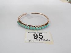 A 14ct gold and turquoise bangle