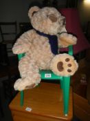 A Teddy bear & green plastic chair