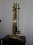 A tall brass companion set