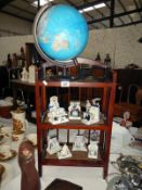 A dark wood stained & wicker book shelves & an electric light up globe