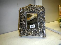 A silver framed mirror (cherubs on frame)