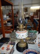 A Victorian oil lamp with painted vessel